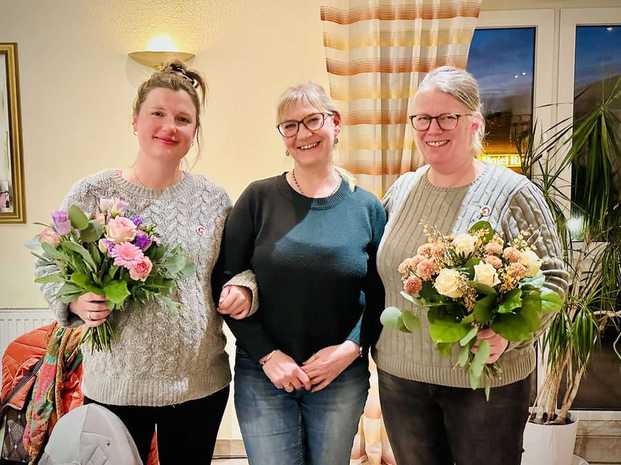 Nicole Kalkenbrenner gratuliert Janine Kopmann und Pia Rübsamen mit Blumensträußen zu 25 Jahren Mitgliedschaft