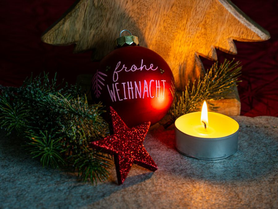 A christmas ornament next to a lit candle